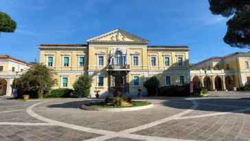 Facciata principale dell’ospedale Spallanzani di Roma con cortile centrale, fontana e cielo sereno.