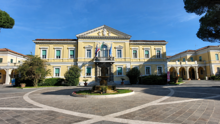Facciata principale dell’ospedale Spallanzani di Roma con cortile centrale, fontana e cielo sereno.