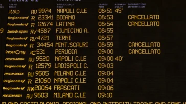 Tabellone degli arrivi ferroviari in una stazione italiana con diversi treni cancellati e ritardi segnalati durante una giornata di sciopero del trasporto ferroviario.