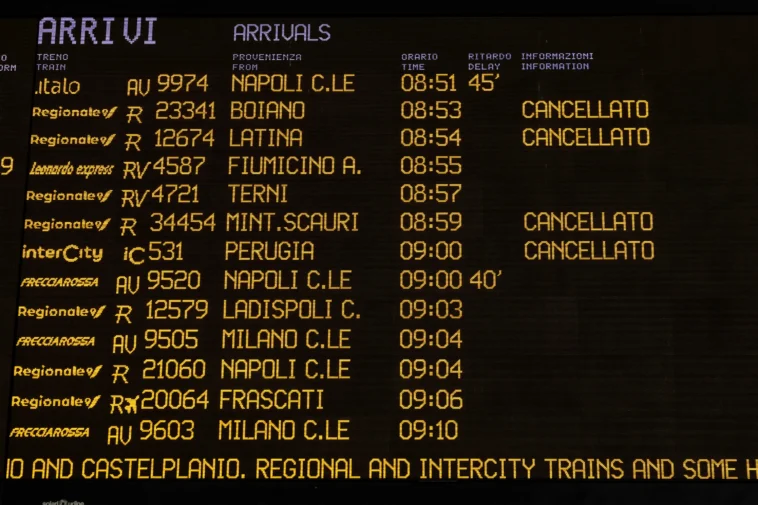 Tabellone degli arrivi ferroviari in una stazione italiana con diversi treni cancellati e ritardi segnalati durante una giornata di sciopero del trasporto ferroviario.
