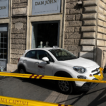 Il taxi coinvolto nell'incidente fermo sul marciapiede davanti a un negozio di via del Tritone, transennato dalla polizia locale dopo aver terminato la sua corsa contro la vetrina.