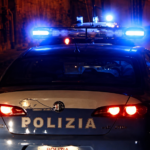 Auto della Polizia di Stato con i lampeggianti accesi durante un intervento notturno in una strada di Roma.