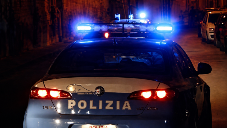 Auto della Polizia di Stato con i lampeggianti accesi durante un intervento notturno in una strada di Roma.