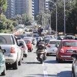 Traffico intenso su una strada di Roma, con auto e scooter in coda vicino a un'area interessata da lavori e modifiche alla viabilità.