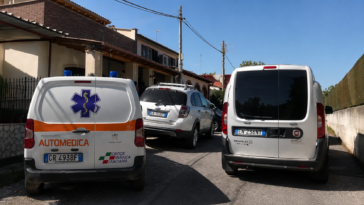Automedica e altri veicoli parcheggiati davanti ad alcune abitazioni in una strada residenziale di Roma.