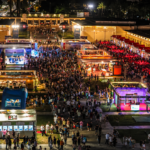 Grande evento serale a Roma con migliaia di persone tra stand illuminati, aree espositive e spazi dedicati all’intrattenimento.