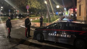 Carabinieri durante un intervento notturno a Roma con una pattuglia parcheggiata lungo la strada.