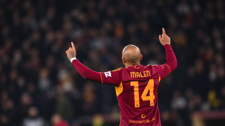 Calciatore della Roma con la maglia numero 14 visto di spalle durante una partita, con le braccia alzate.