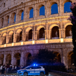 Colosseo illuminato di notte a Roma con una pattuglia della Polizia davanti all’Anfiteatro Flavio.