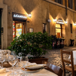 Tavoli apparecchiati all’aperto davanti al ristorante La Campana, in una strada del centro storico di Roma.