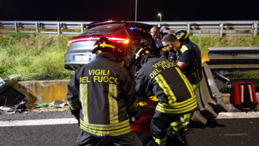 Vigili del Fuoco durante le operazioni di soccorso accanto a un’auto finita fuori strada contro il guardrail nella notte.